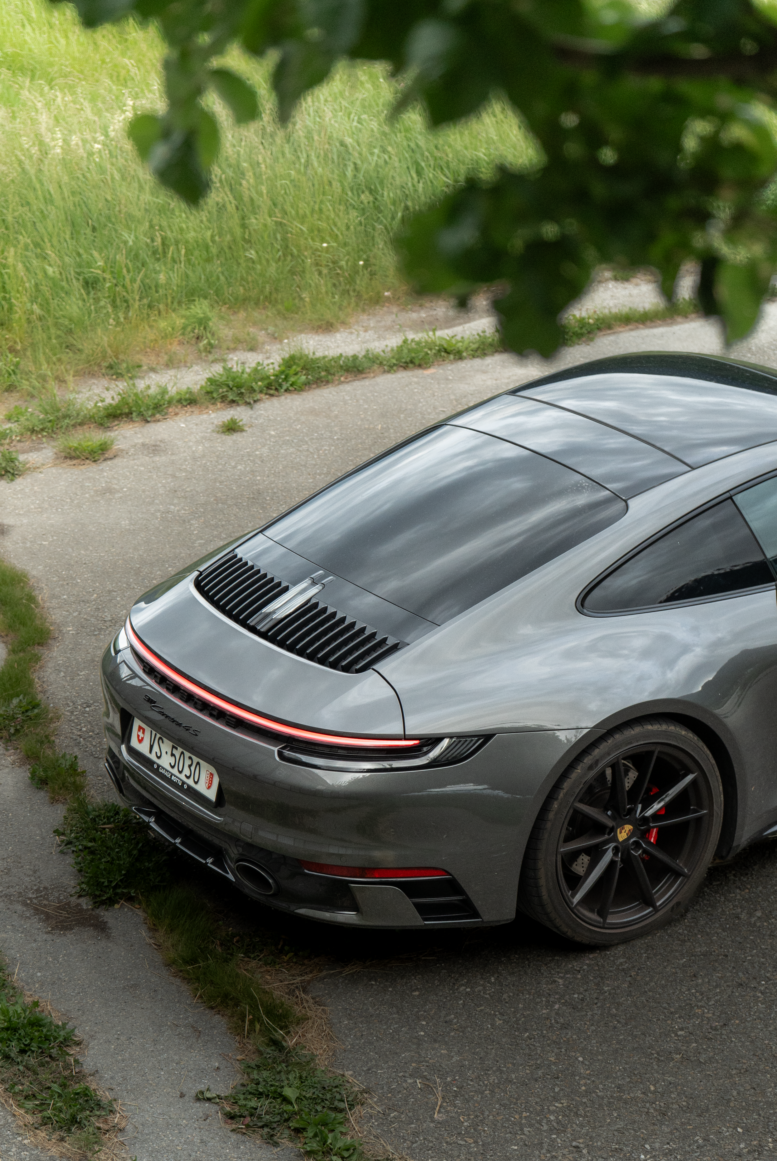 Oldtimer-Heckflosse vor minimalistischer Betonwand